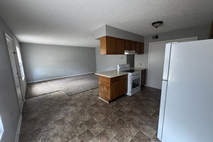 Kitchen opening onto the dining area, with vinyl flooring