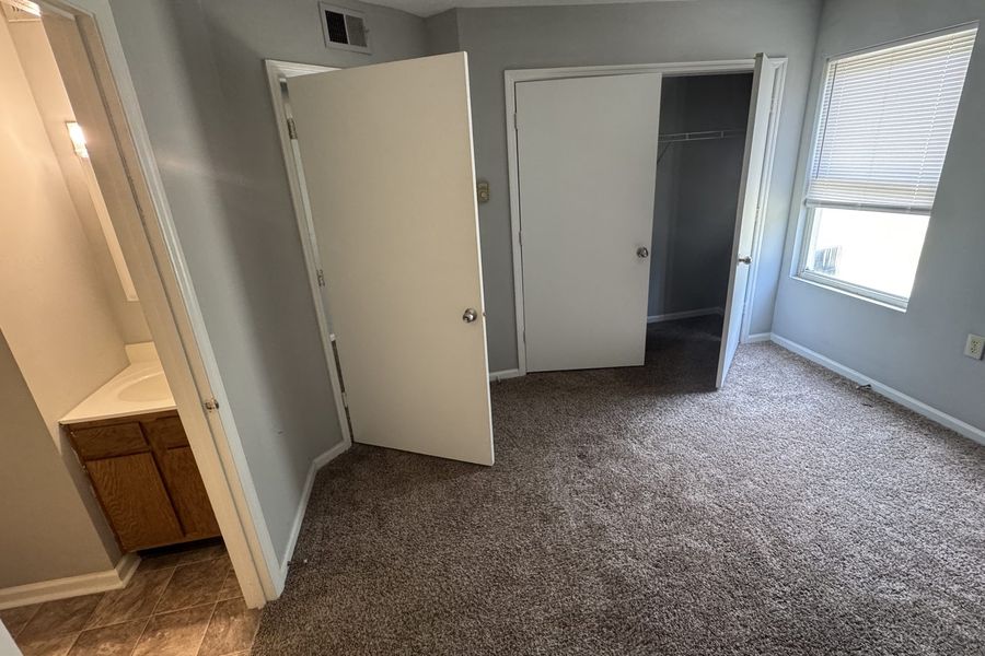 Primary bedroom showing the closet and the vanity in the adjoining bathroom