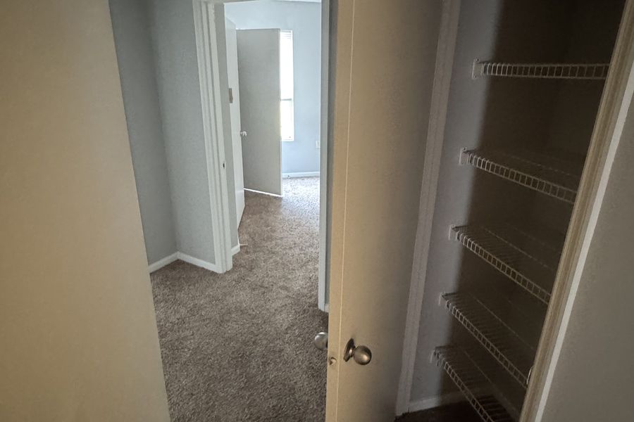 Hallway linen closet with built-in shelving